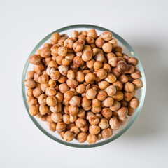 Chickpeas in a transparent bowl on a white background