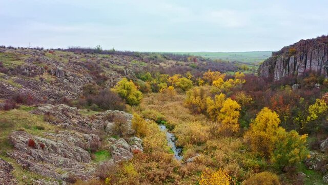 Aktovsky Canyon, Ukraine. Autumn trees and large stone boulders around. Aerial UHD 4K drone realtime video, shot in 10bit HLG and colorized