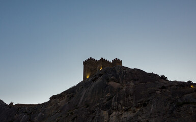 Fototapeta na wymiar Genoese fortress on a high cliff on the Black Sea coast in Sudak in the late evening.