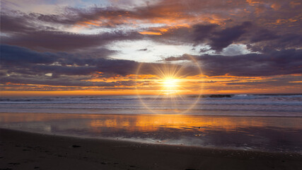 Golden sunrise across the ocean on a beach - 401573263