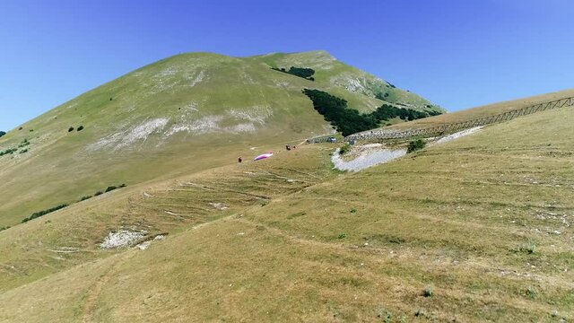 Aerial drone view during a paragliding flight from a mountain, breathtaking panorama. It feels like walking on the tip of the mountains, fun and adrenaline while flying