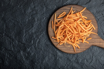 Wide angle julienne of organic fresh carrot on wooden board