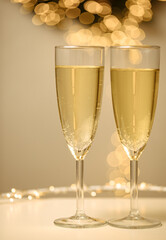 two glasses of champagne with white background and lights