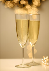 two glasses of champagne with white background and lights