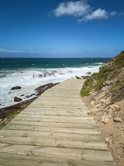 Fototapeta na wymiar Scenic view of wooden footpath along hiking trail at Robberg Nature Reserve, Plettenberg Bay, South Africa.