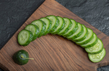 Close up sliced fresh cucumber photo on wooden board
