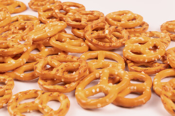 Densely sprinkled salty cookie crackers on a white surface