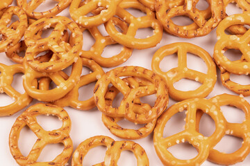 Scattered chaotically salted crackers close up on white background