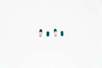 4 capsule pills lined up on a white background