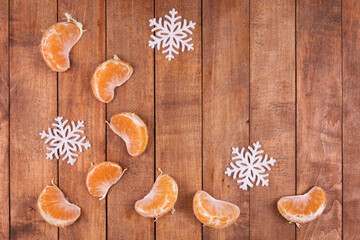 Slices of juicy tangerine with Christmas tree decorations in the form of snowflakes