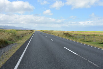Fototapeta na wymiar View of straight asphalt road in Hauraki Plains