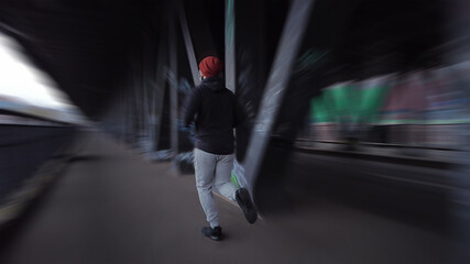 young guy is running over tunnel bridge in Hamburg Germany, Cool zoom or motion speed effect, New Year's resolutions, Jogging or running in the urban city.