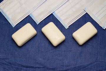 flat lay with antibacterial soap and medical masks on denim background