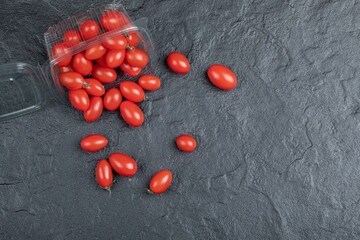 Fresh organic small red tomatoes on black background