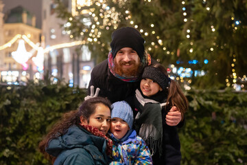 Happy multinational family outdoor in a city center at Christmas
