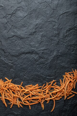 Close up Julienne of fresh organic carrot over black background