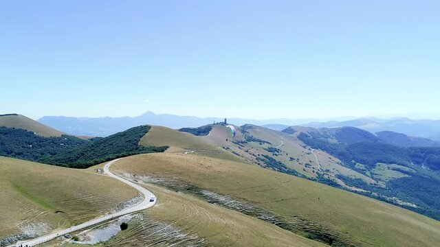 Aerial drone view during a paragliding flight from a mountain, breathtaking panorama. It feels like walking on the tip of the mountains, fun and adrenaline while flying