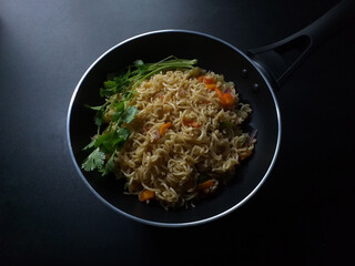 Traditional black pan of instant noodles dark background