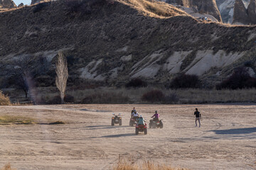 People doing safari with ATV motors in Cappadocia with the scenery of fairy chimneys