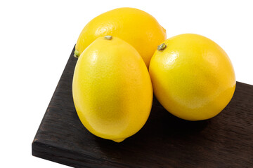 Yellow juicy fresh lemons on a cutting kitchen board, isolate on a white background.