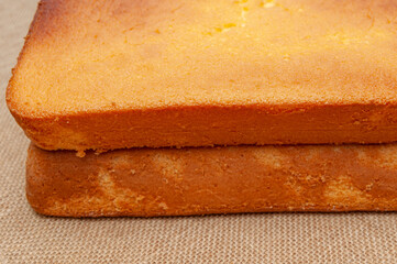 Homemade Sponge Cake, in Portuguese Pão de Ló. Top of the baked cake dough. Isolated on jute background. Front view. Close-up