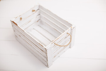 An old empty wooden box on old white background. Scratched vintage white box with peeling paint. Shabby chic or rustic style