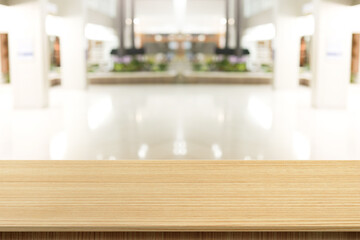 Empty wooden table in front of a blurred background. Brown wood in blurry view in office work - can be used to display or edit your products, simulate to showcase them.