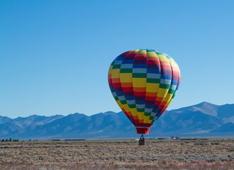 Fototapeta na wymiar Colorful Hot Air Balloon hovering just above ground