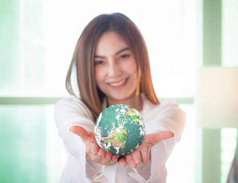 World environment day concept: Selective focus green earth, Asian woman giving world. Elements of this image furnished by NASA
