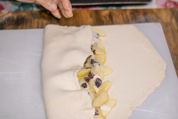 Cutting apple slices. Ingredients for making apple strudel. Latina cuts a yellow apple in half. Cooking apple strudel at home in the kitchen