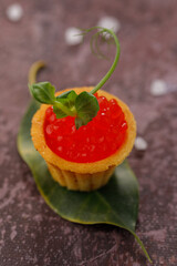 Appetizing tartlet with red caviar and microgreen decor. Holiday concept. Close-up.