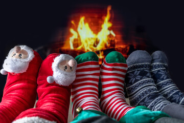 feet of a family of three, father, mother and daughter in front of a chimney with firefeet of a family of three, father, mother and daughter in front of a chimney with fire