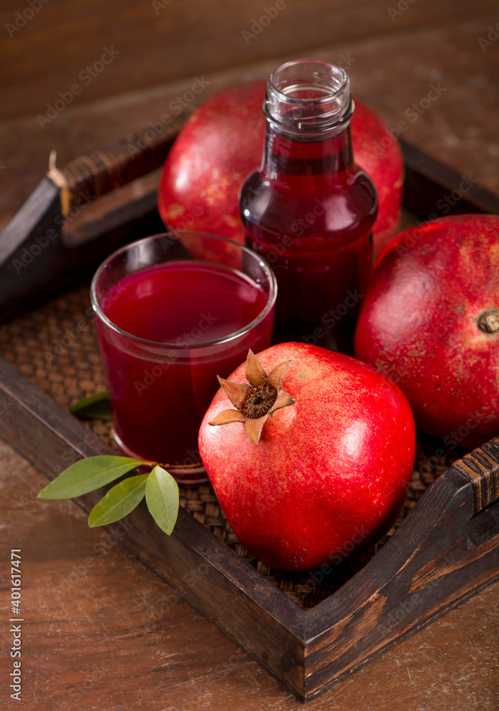 Sticker pomegranate juice and pomegranate fruit on wooden background