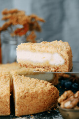 Sour cream cake cut in close-up. Sweet dessert with cream on the table.