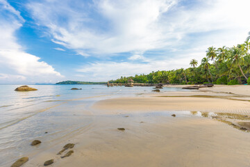 Beautiful summer beach with white sand turquoise ocean against blue sky with clouds and palm tree