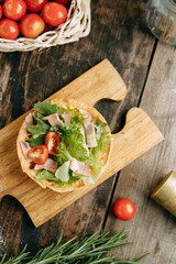 Hot appetizer with mushrooms, chicken and herbs. Tartlet made of yeast-free dough close-up.