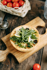 Hot appetizer with mushrooms, chicken and herbs. Tartlet made of yeast-free dough close-up.