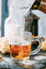 Tea ceremony of pouring boiling water into tea. A stream of tea close-up with steam in a home environment.