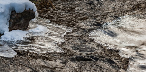 Ice growths close-up on a fast-flowing river in winter