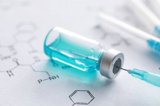 small jars with injection and syringe for injection on a blue background near the chemical formula - Powered by Adobe