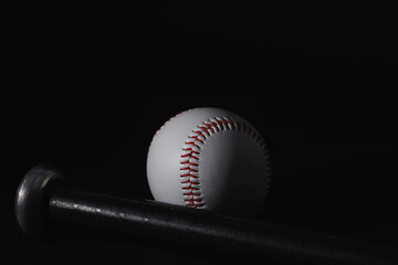American traditional sports game. Baseball. Concept. Baseball ball and bats on a black table.
