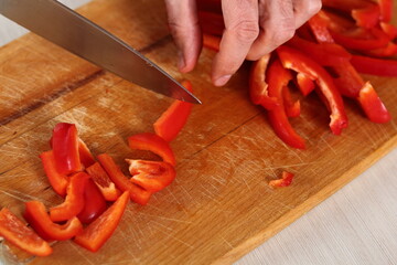 Chef slicing red bell pepper