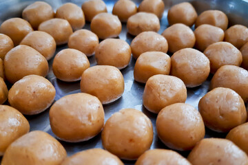 Brown Pera or pedha is an indian sweet made using khoa, sugar and traditional flavorings, including cardamom seeds, pistachio nuts. served in a bowl or plate. selective focus
