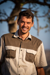 Close-up of smiling safari guide near tree © Nick Dale