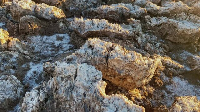 Close-up of rough ground with salt with Golden sunset light at Devils Golf course at Death Valley National Park, CA, USA. Slider left to right.