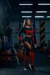 Fototapeta na wymiar Muscular young fitness sports woman workout with dumbbells in fitness gym.