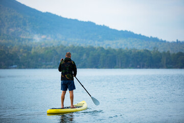 a man on the lake ride a sup board. high quality photo