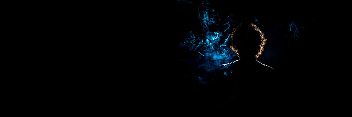 Colored silhouette of a smoking man on dark background. Banner panoramic. Copy space for text message.