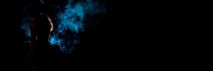 Colored silhouette of a smoking man on dark background. Banner panoramic. Copy space for text message.