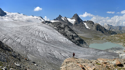 Trekker admire Rutor glacier, Vedette and Grand Assaly on background